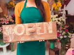 mulher segurando placa de open, abrir novo negócio
