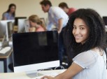 jovem sentada à mesa com computador