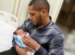 homem segurando bebê recém-nascido