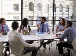 foto de pessoas sentadas conversando em volta da mesa